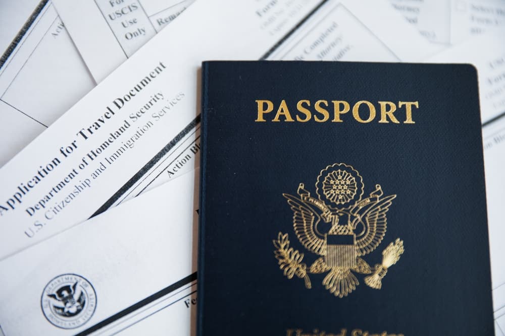 Passport with immigration, visa, citizenship, and travel paperwork on a table