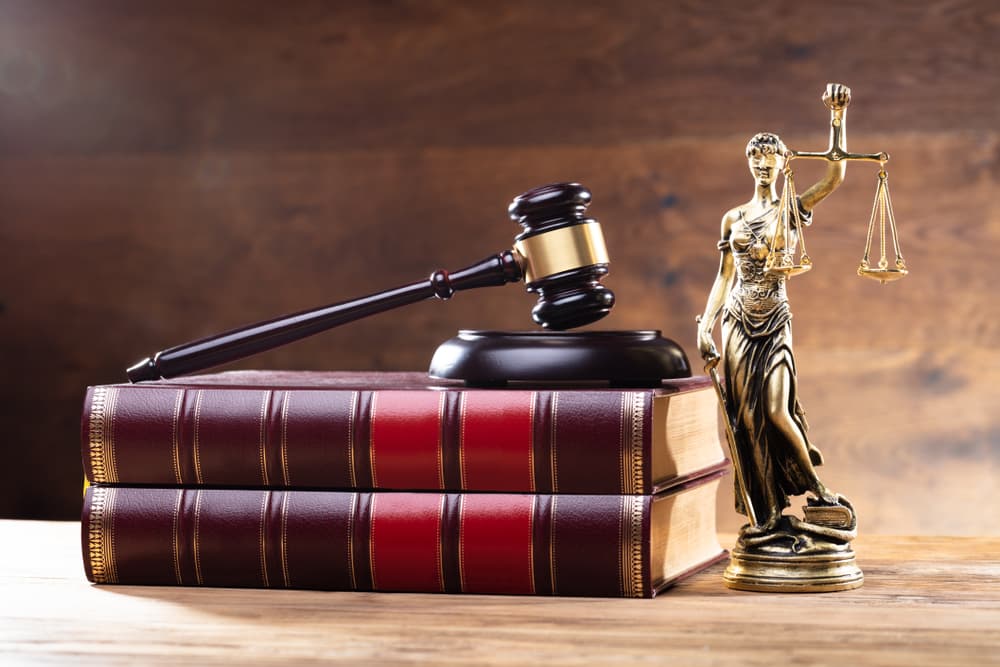 Close-up Of Golden Lady Justice Near Wooden Gavel Over Law Book.