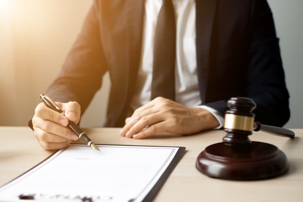 The lawyers, seated in their office, meticulously examine judicial documents to gather crucial information and build a strong legal strategy for their case.