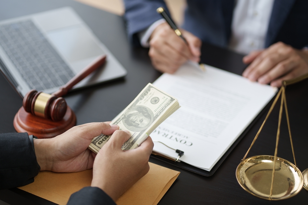 A close-up view of a young lawyer signing a contract after finalizing a deal with his client, capturing the moment of agreement.