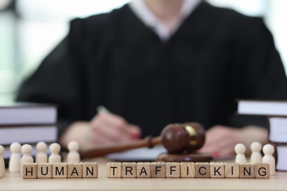 Human Trafficking with wooden cubes on judge counter in courtroom