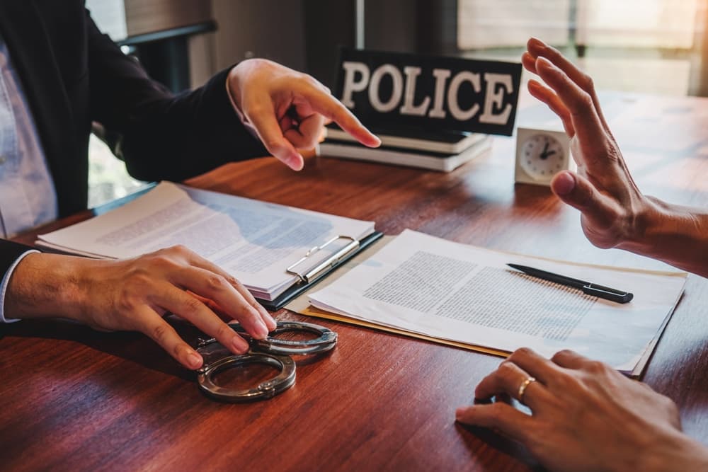 Law enforcement officer interrogating Criminals male with handcuffs in the investigation room Police officer interviewing after fighting in Bar