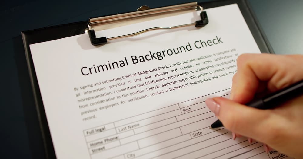 Hand Filling Criminal Background Check Application Form