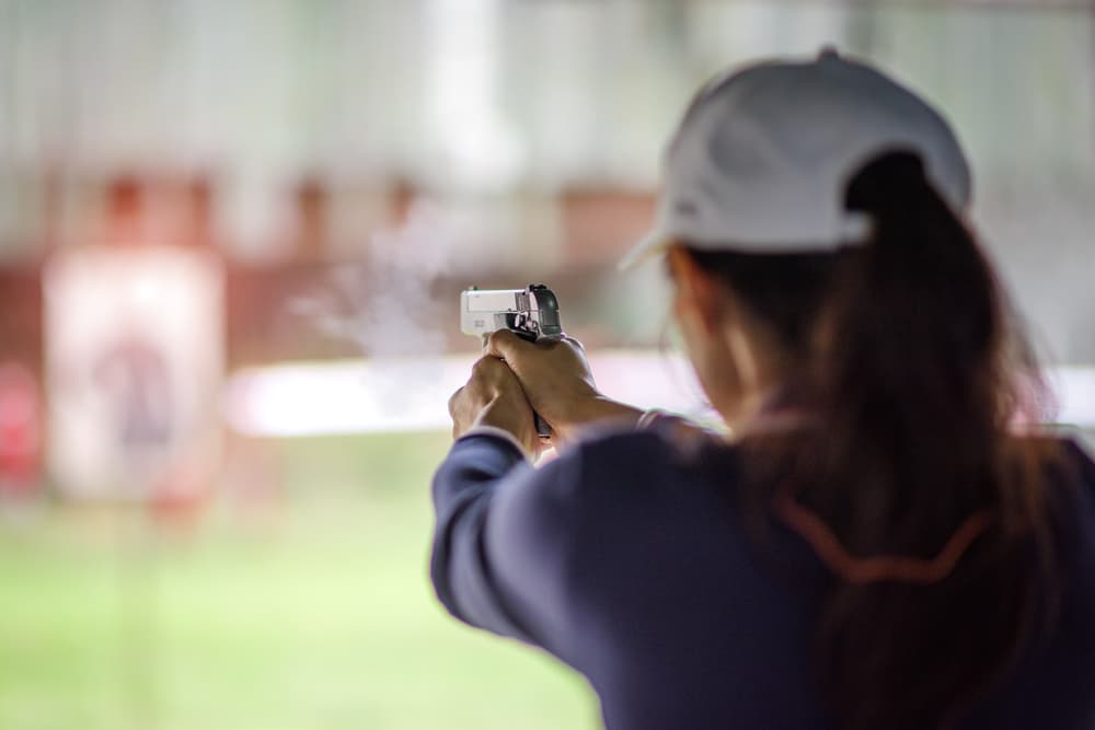 Gun holding in hand of woman in practice shooting for self defense