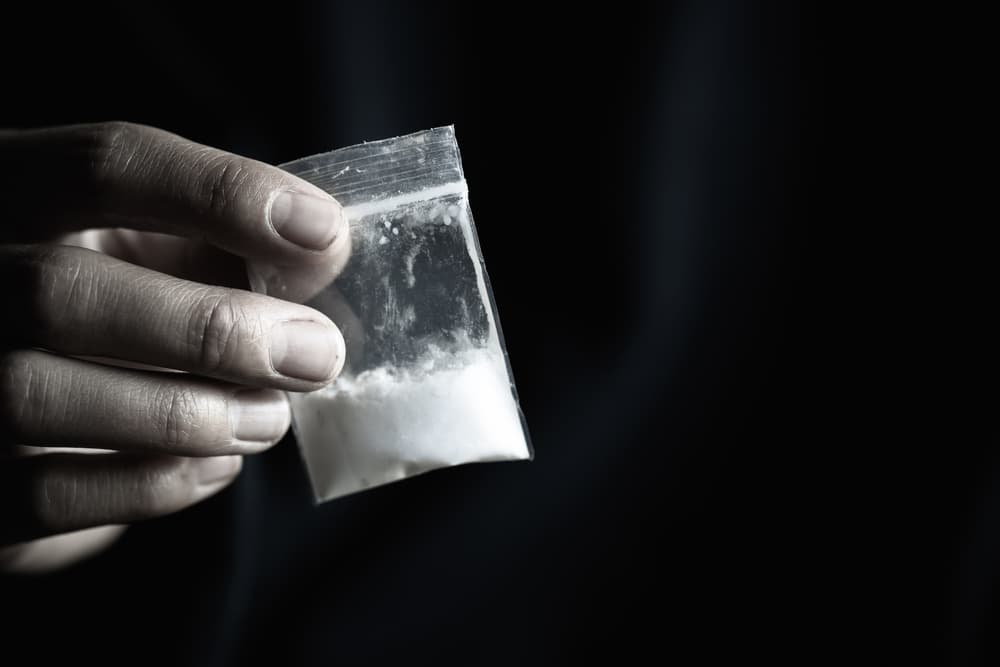 A young guy possess a clear bag of illegal drugs