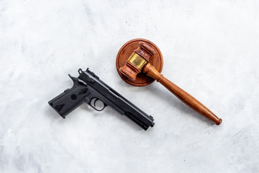 Hand gun weapon and judges gavel - gun law. Illegal use of weapons concept