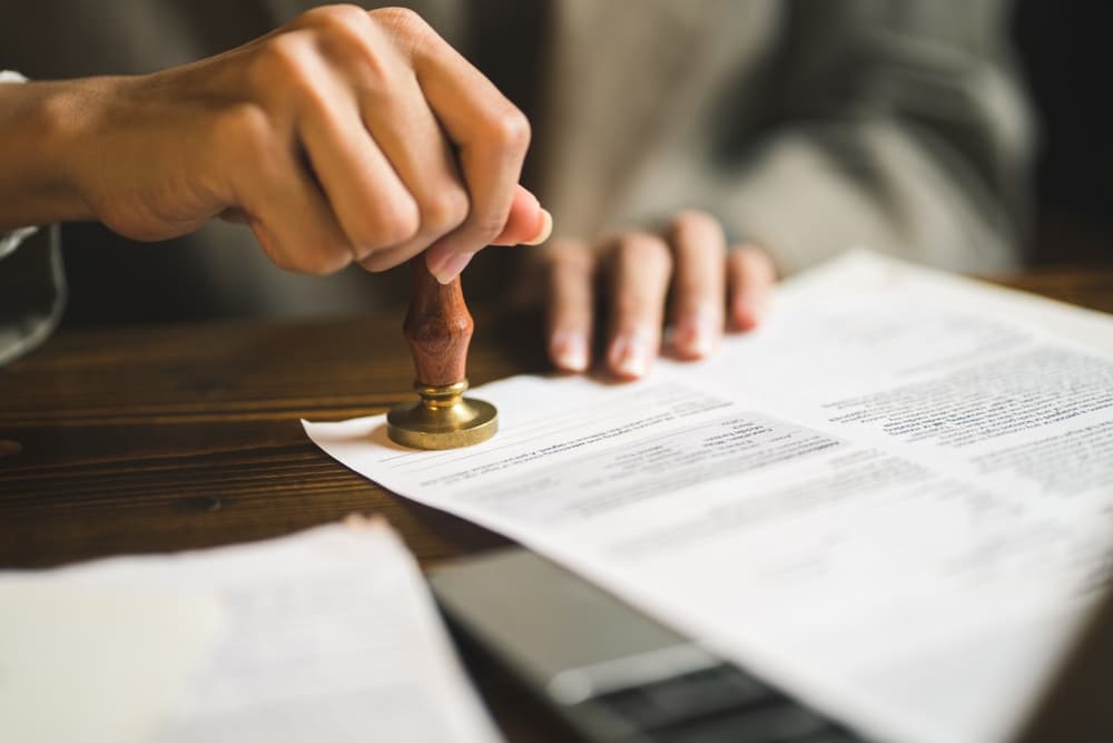 person stamping documents to seal the criminal record